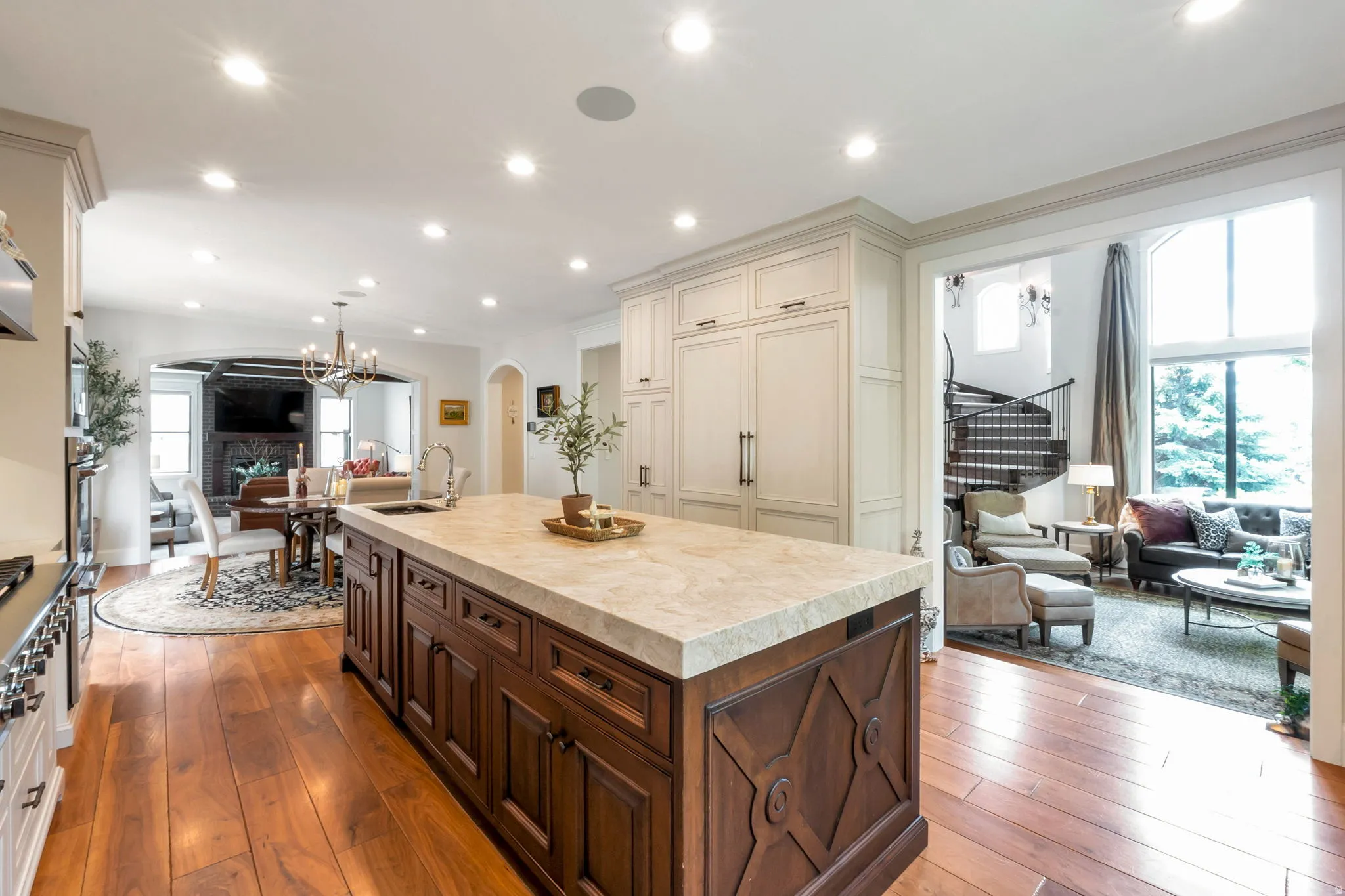 Kitchen island featuring a light-toned countertop, rich wood cabinetry, and recessed lighting