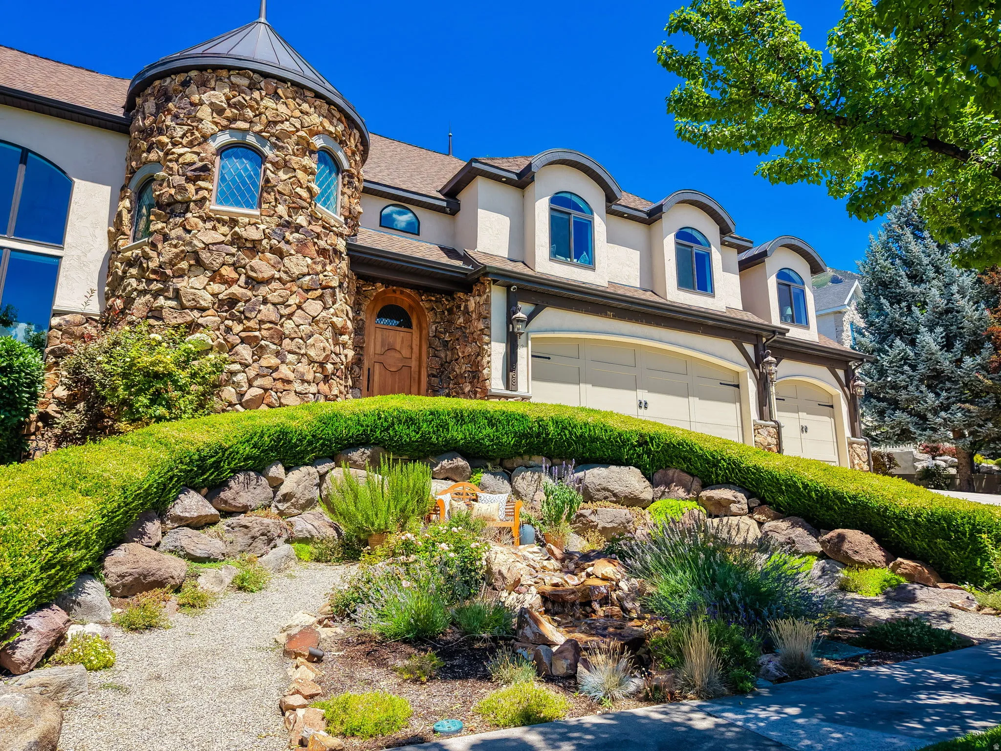 Stone turret exterior with arched windows, stucco siding, and a wooden entry door