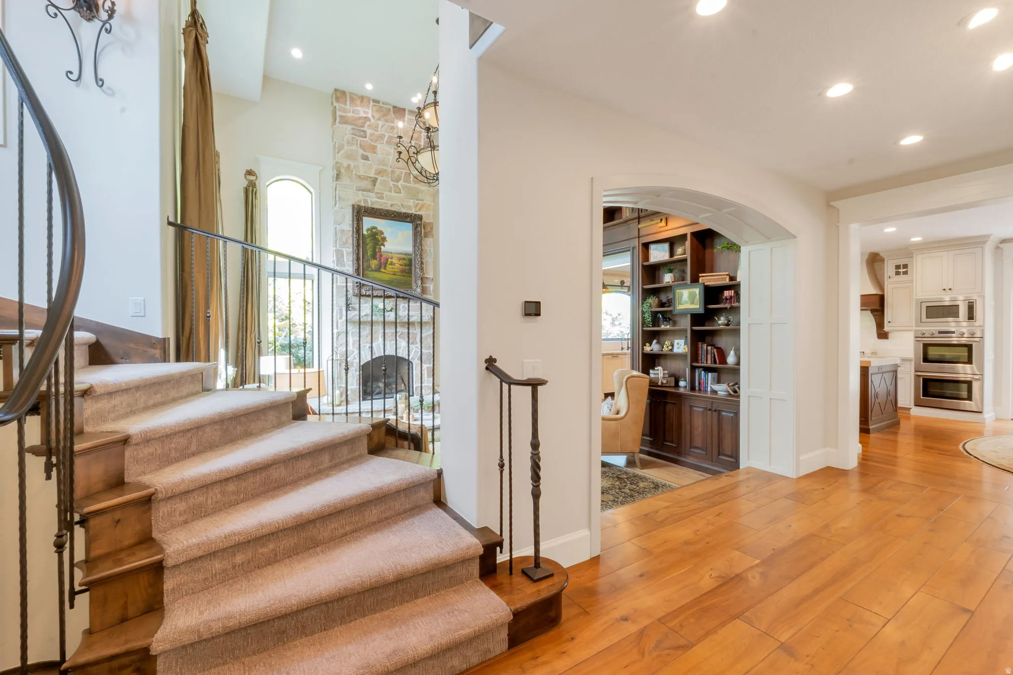 Carpeted staircase with wrought iron railing