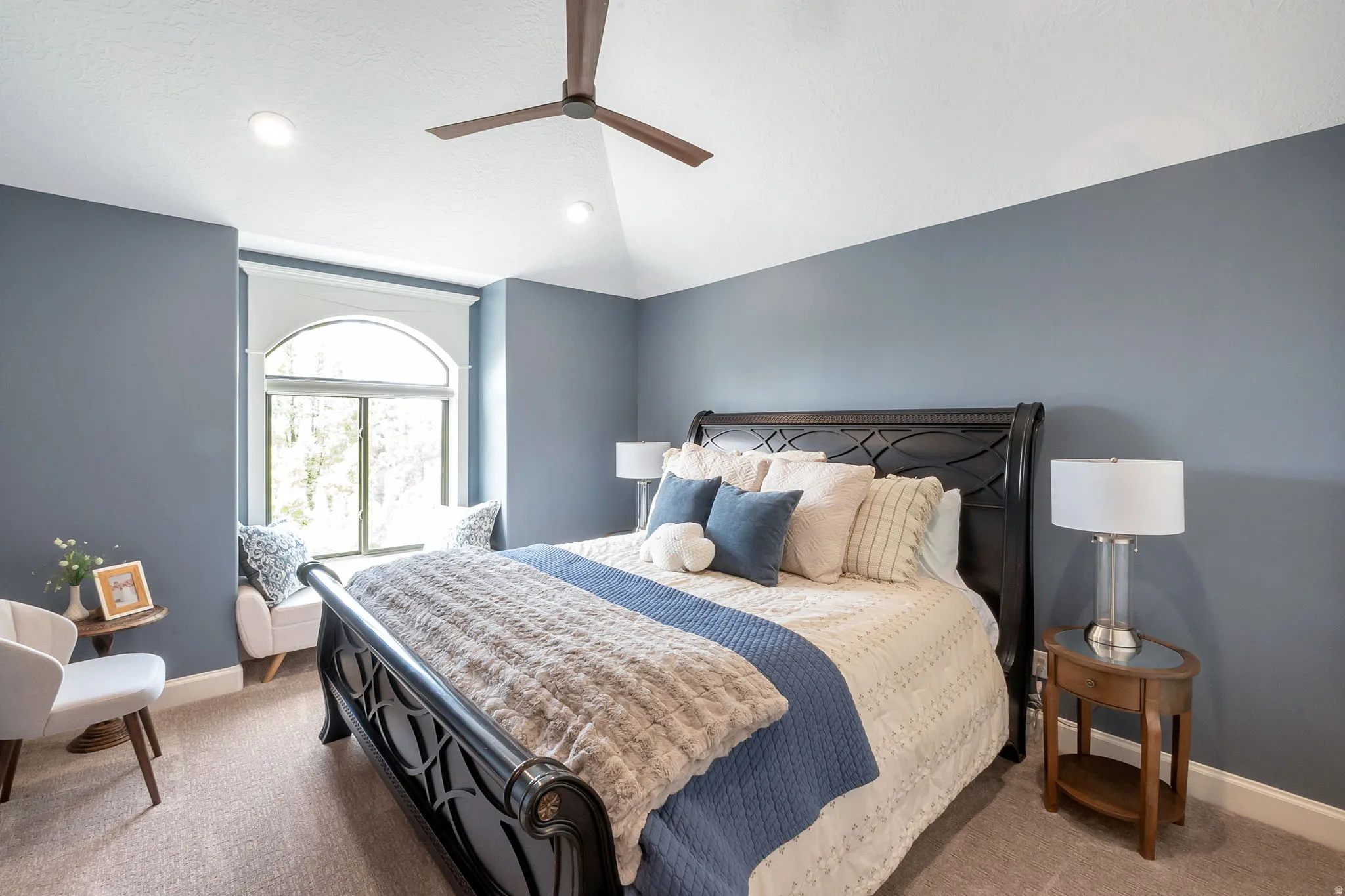 Bedroom featuring a vaulted ceiling with a ceiling fan, recessed lighting, and an arched window with a window seat