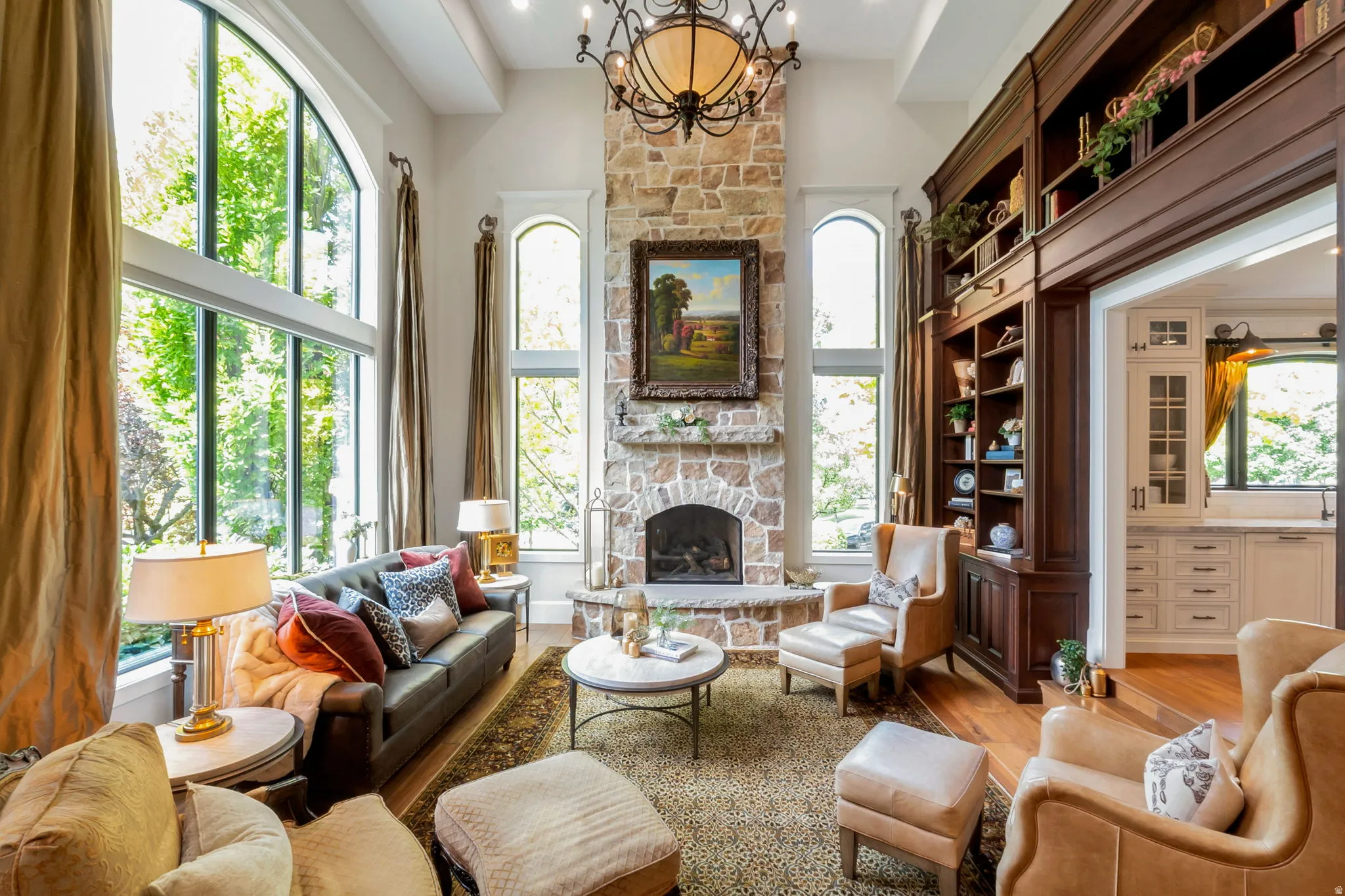 Living area with a stone-clad fireplace and a high arched window