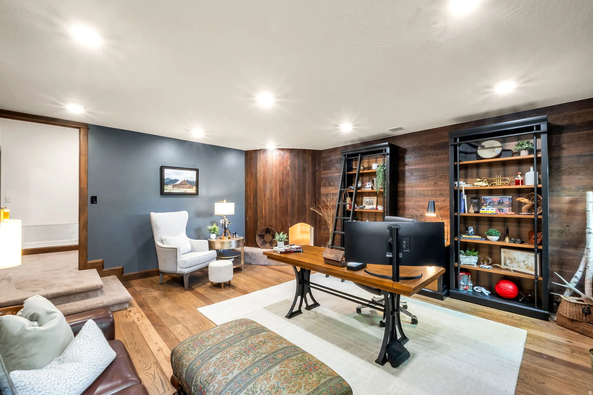 Lower-level room with recessed lighting and warm wood-finish flooring