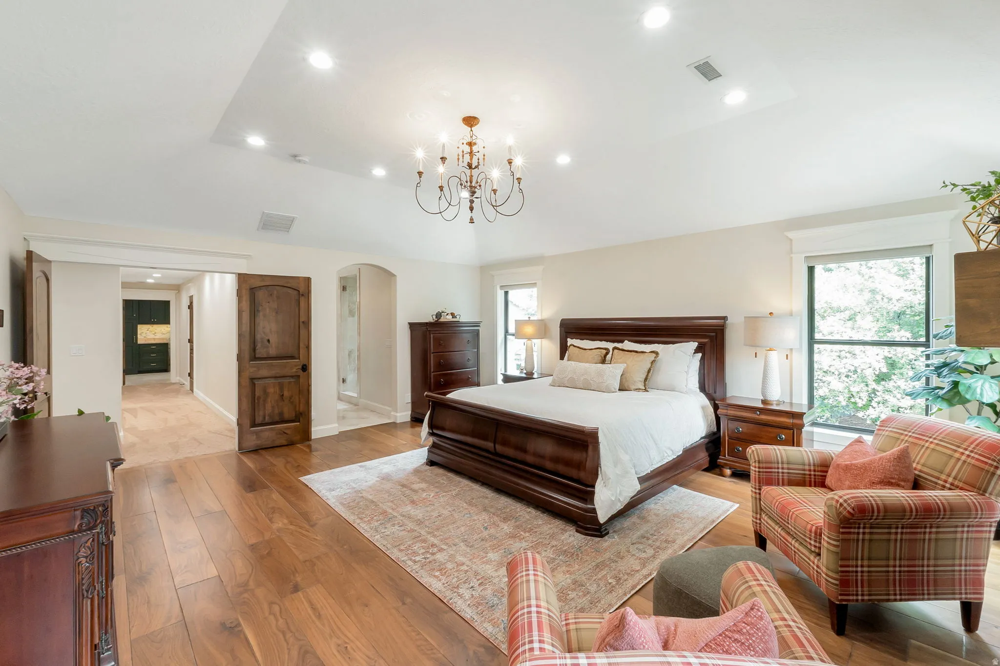 Spacious sleeping area featuring wood-finish flooring, recessed lighting, and a decorative chandelier