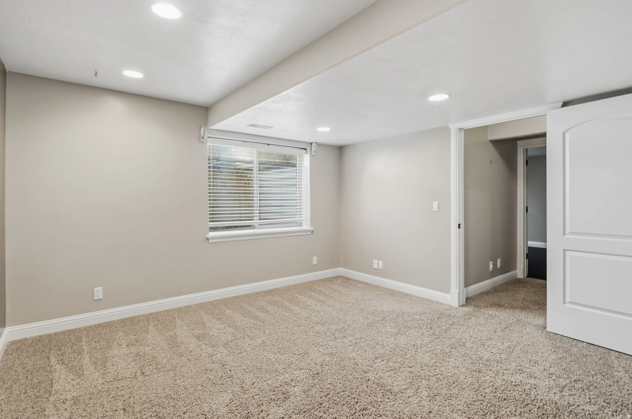 Spacious room featuring neutral carpeting and light-toned walls