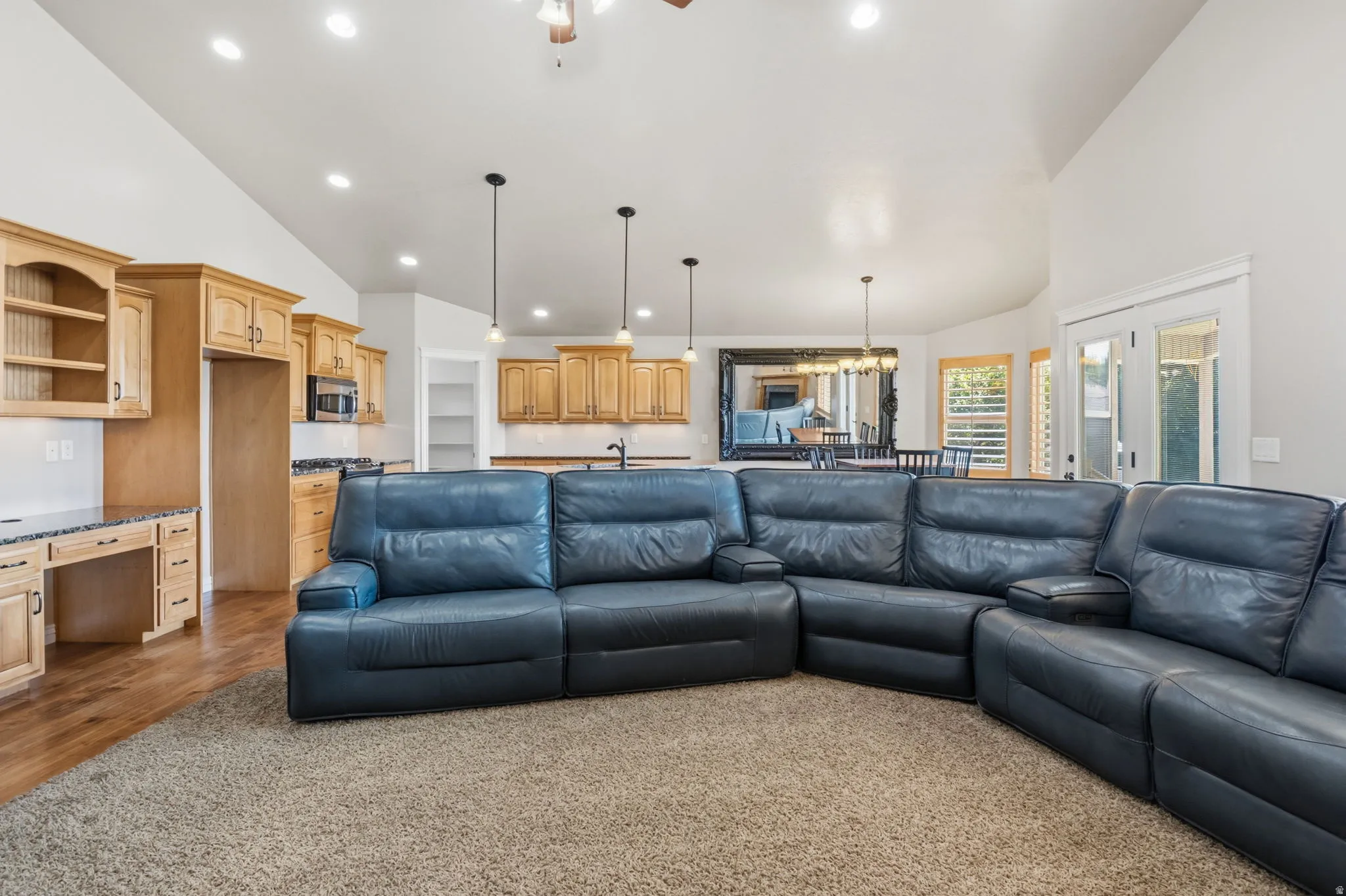 Open-concept living space featuring vaulted ceilings and recessed lighting
