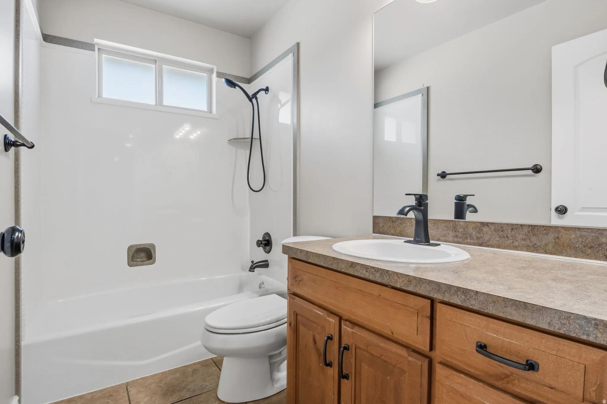 Bathroom featuring a single vanity with wood cabinetry, a surface-mount sink, and a dark bronze faucet