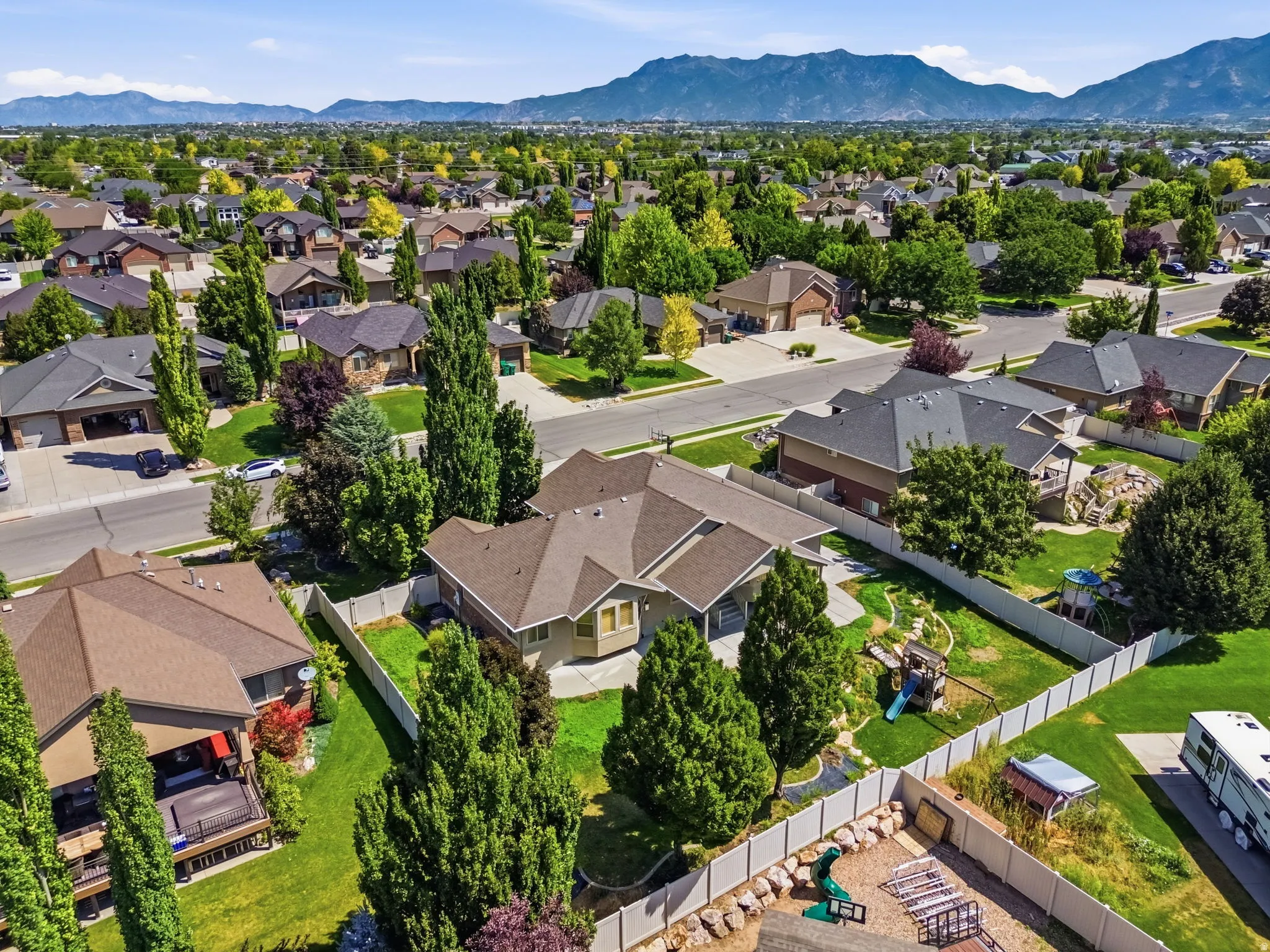 Spacious residential property featuring a large backyard, mature landscaping, and a fenced perimeter