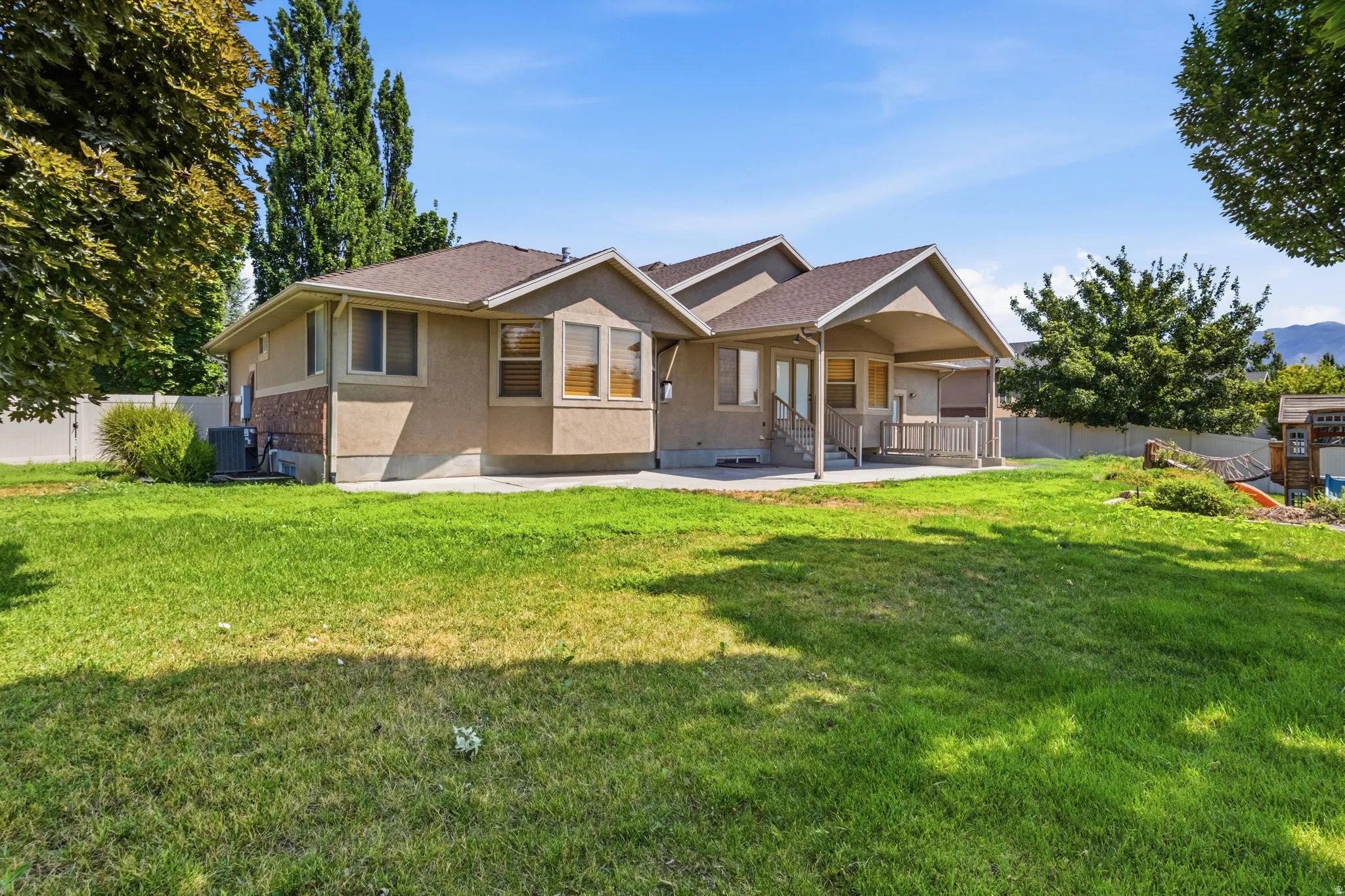 Spacious rear yard with a covered patio and concrete slab