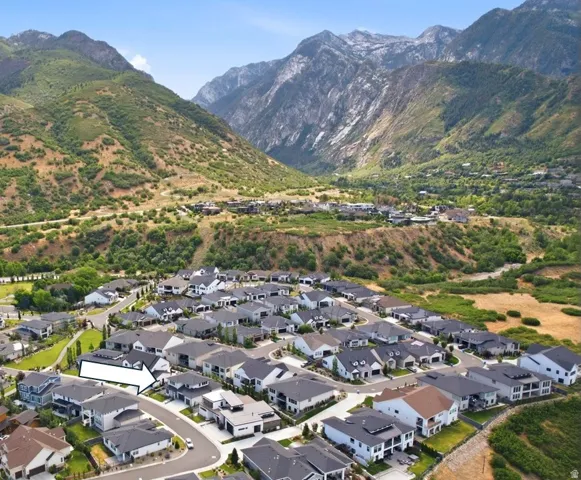 Aerial view of a residential neighborhood with varied architectural styles, featuring gray and white exteriors and dark roofing