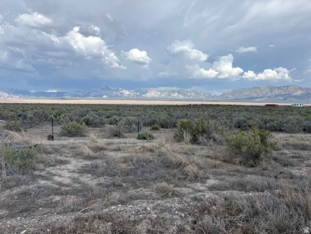 Expansive acreage with natural desert landscaping and distant mountain range backdrop