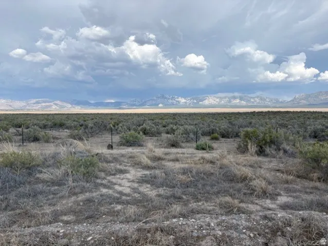 Expansive open land with natural desert vegetation and distant mountain ranges