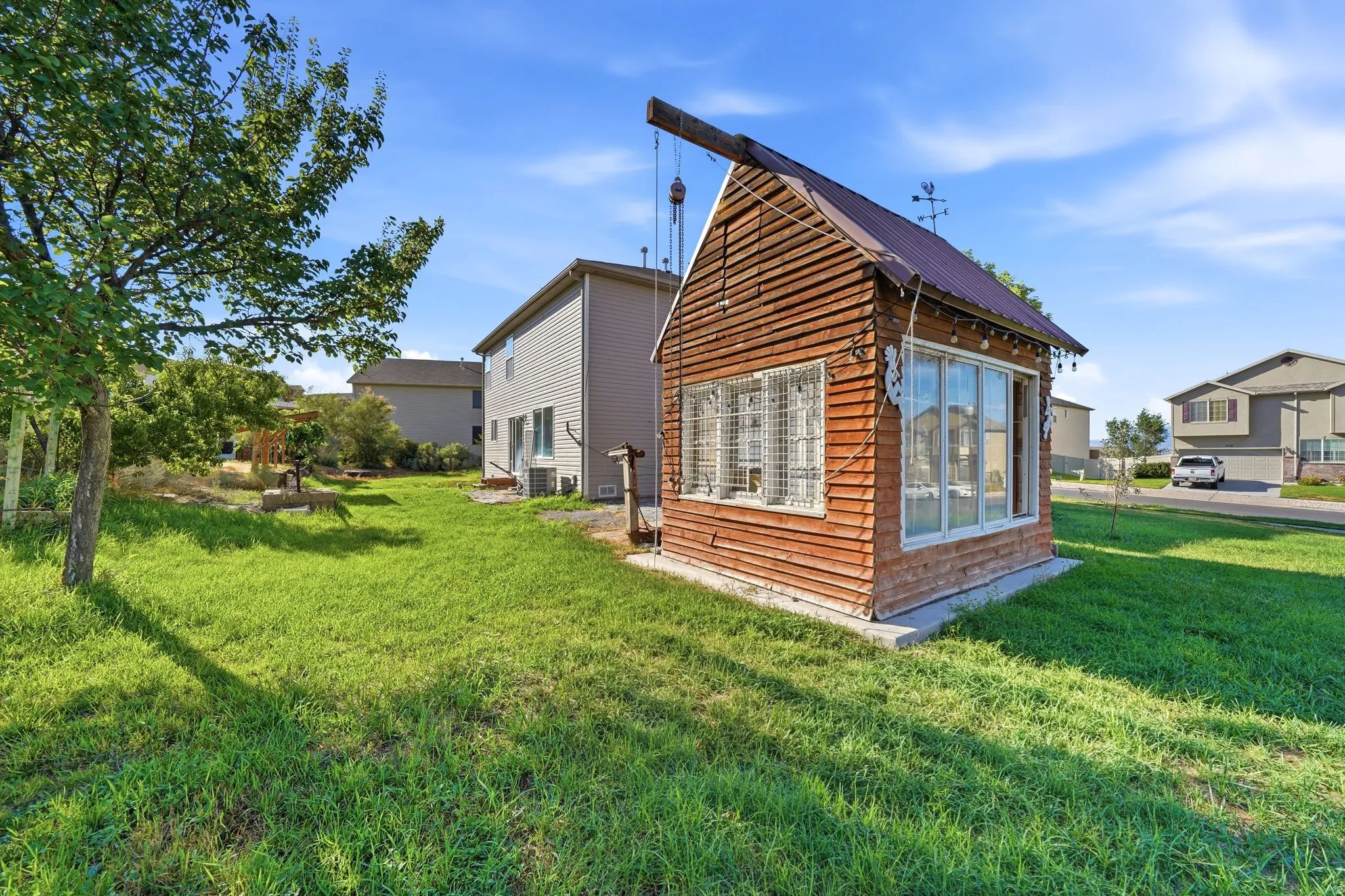 Exterior shed featuring horizontal wood siding, a metal roof, and multiple window panels