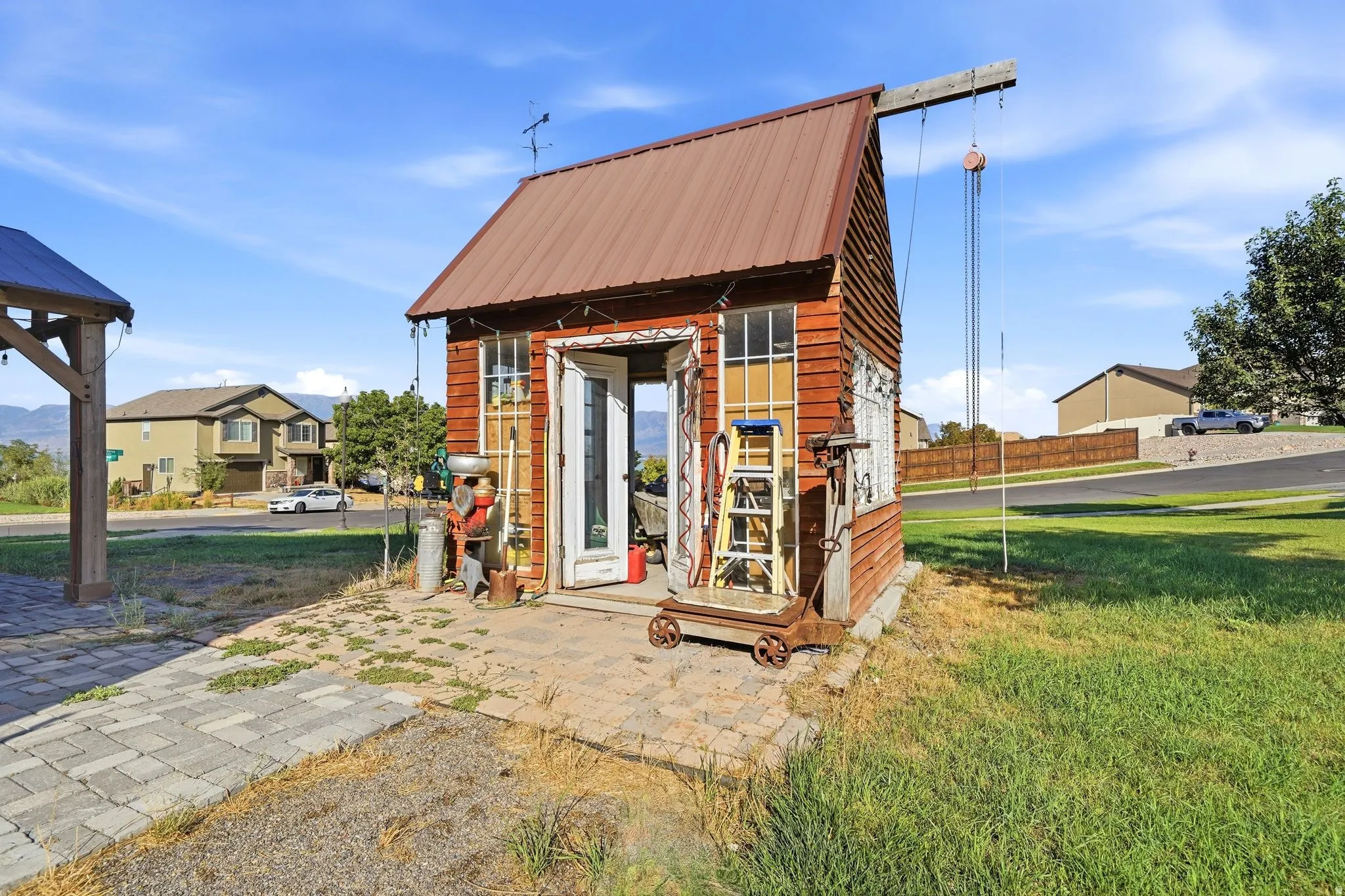 Freestanding outbuilding with a brown metal roof and cedar-style siding