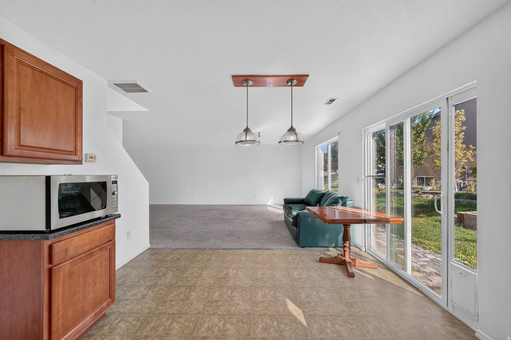 Kitchen area featuring wood cabinetry, dark countertop, and tile flooring