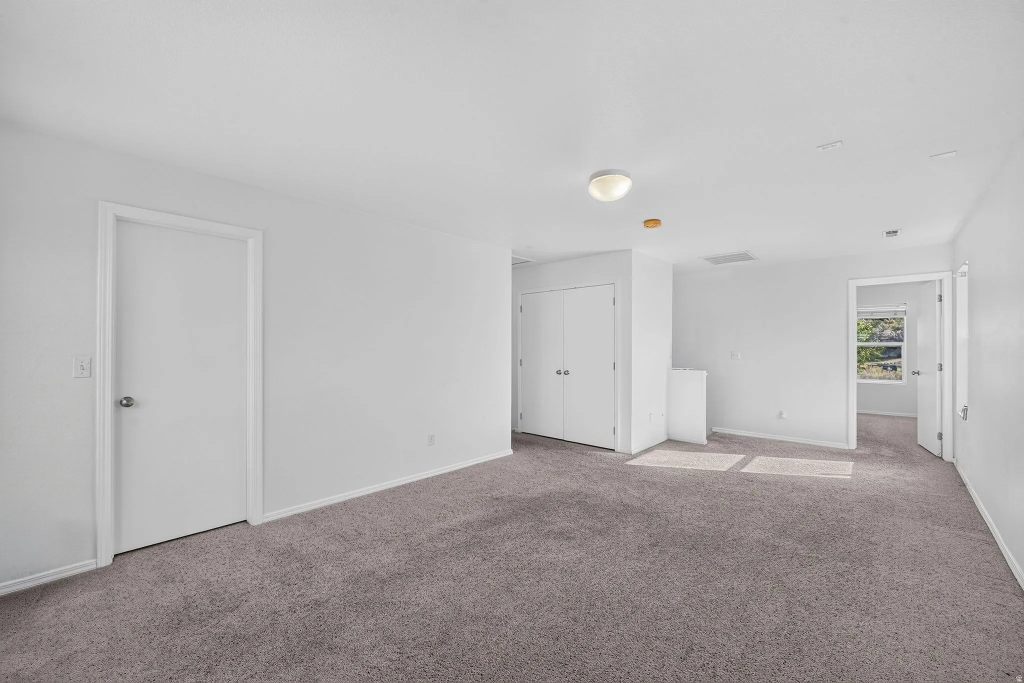 Carpeted interior space featuring white walls and trim