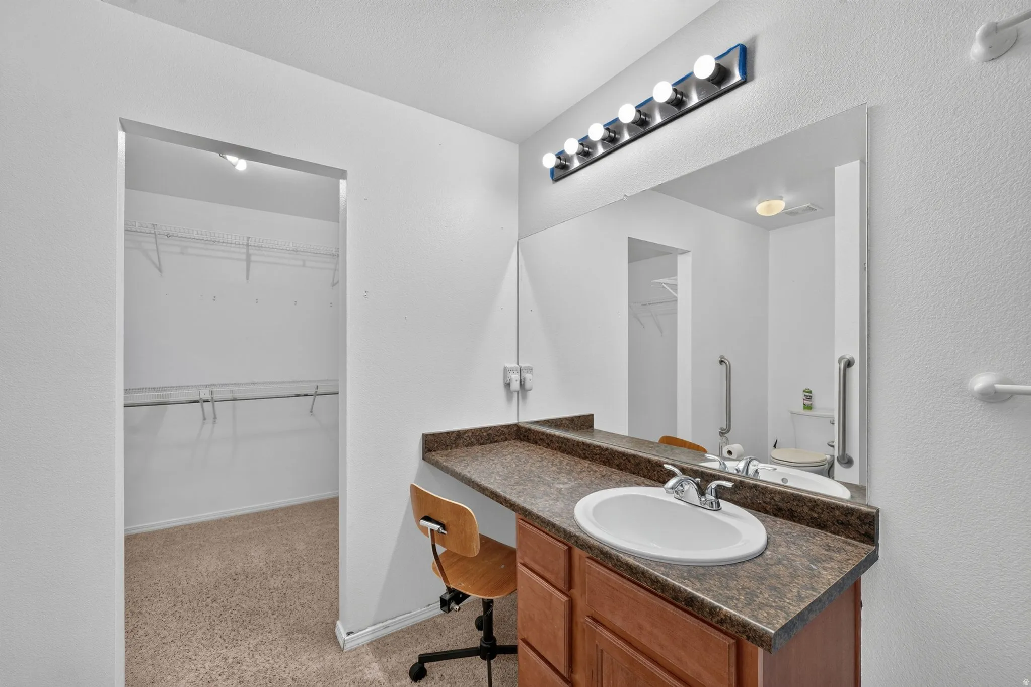 Vanity area featuring an integrated sink, laminate countertop, and wood-finish cabinetry
