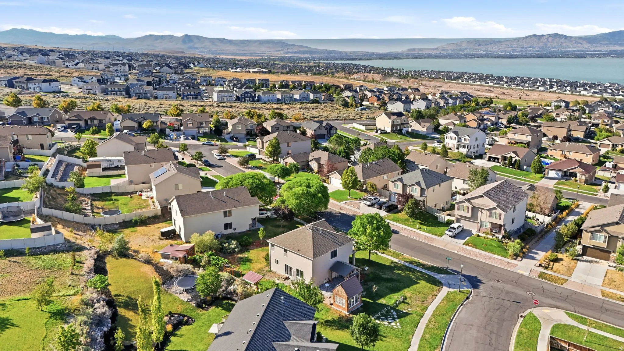 Aerial perspective showcasing a residential neighborhood with varied architectural styles and a distant body of water