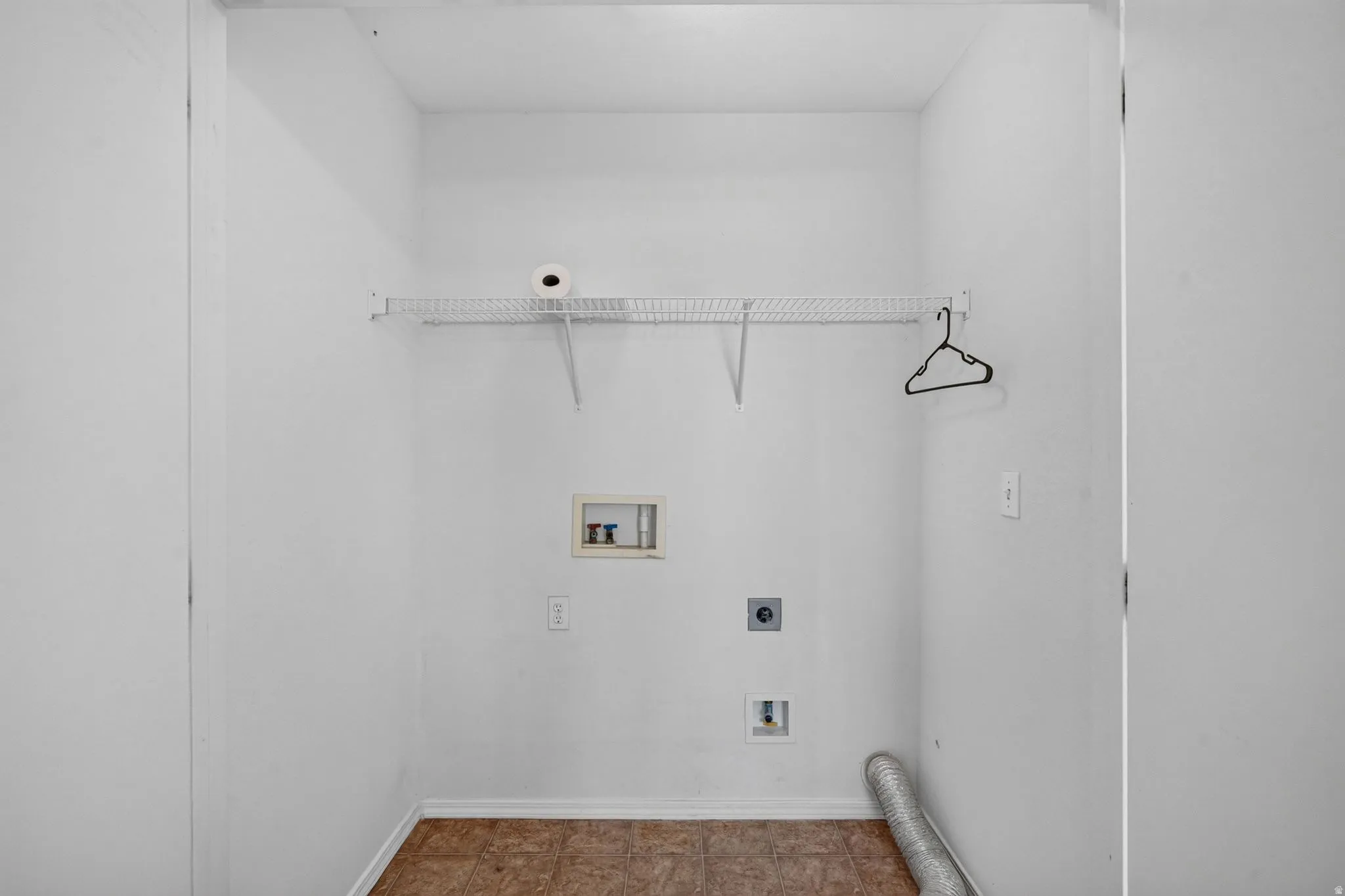Laundry area featuring white walls, wire shelving, wood-finish flooring, and utility hookups for appliances