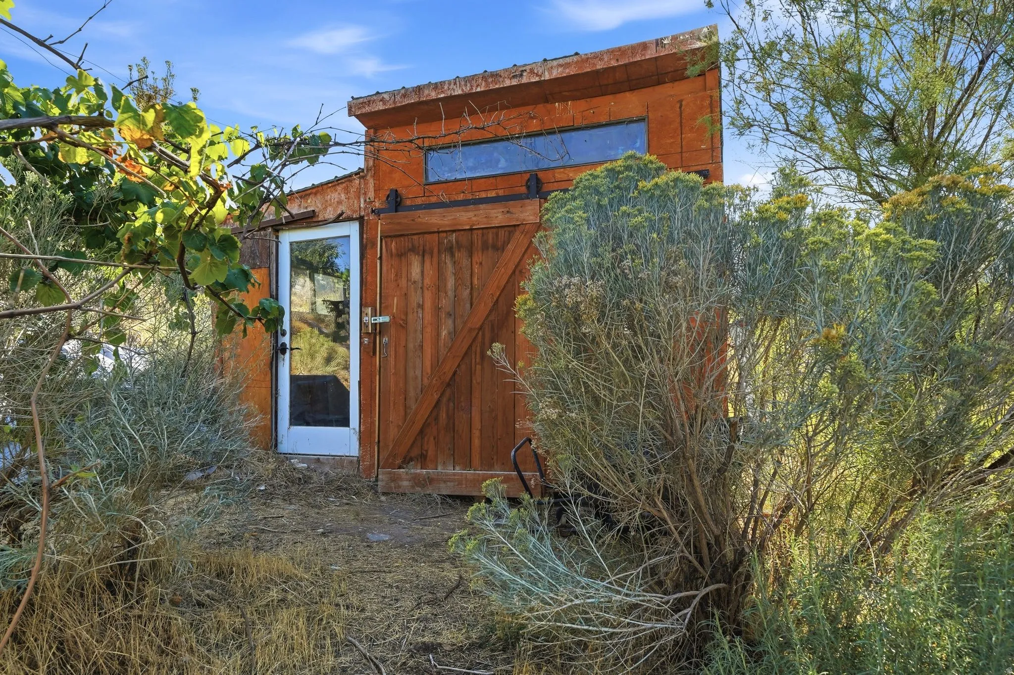 Exterior structure featuring a sloped roofline, wood-finish siding, and a horizontal window