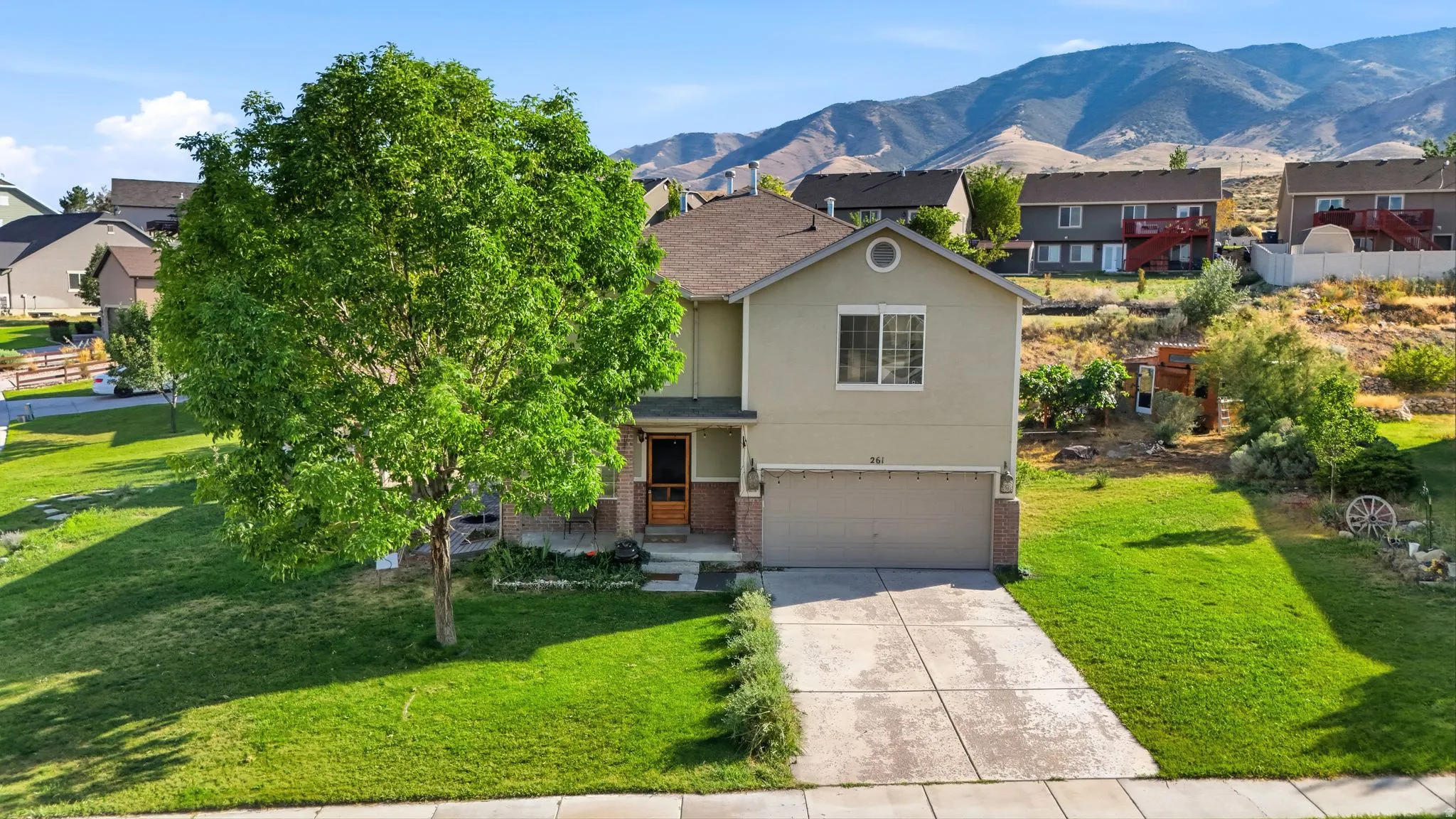 Two-story residence featuring a two-car garage, concrete driveway, and a front entry with a screen door