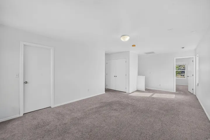Carpeted interior space featuring white walls and trim