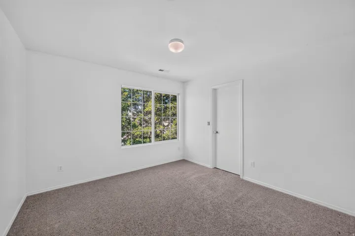 Room featuring white walls, gray carpet flooring, and a multi-pane window