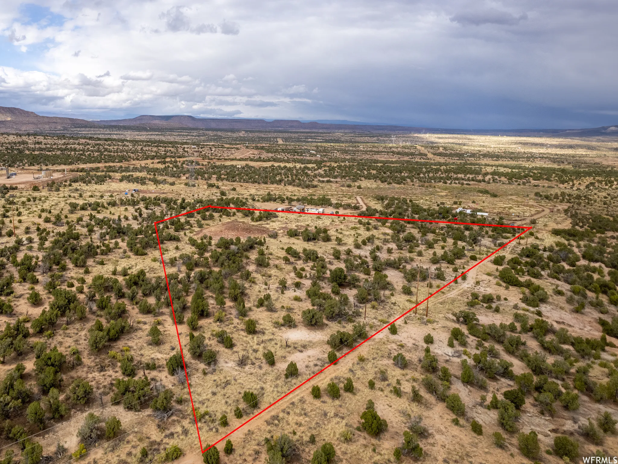 Expansive desert landscape with scattered green shrubbery and distant mountain ranges