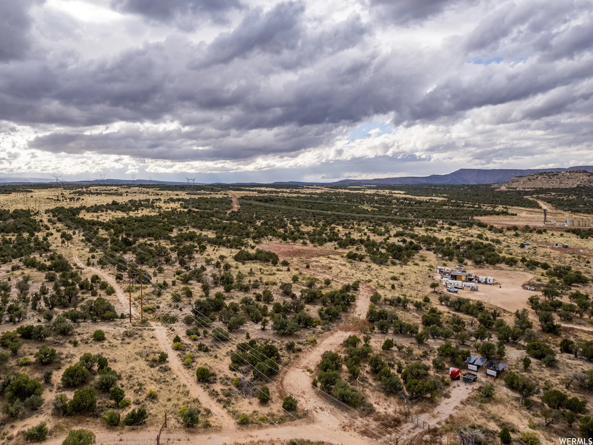 Expansive desert landscape featuring scattered green vegetation and rolling terrain