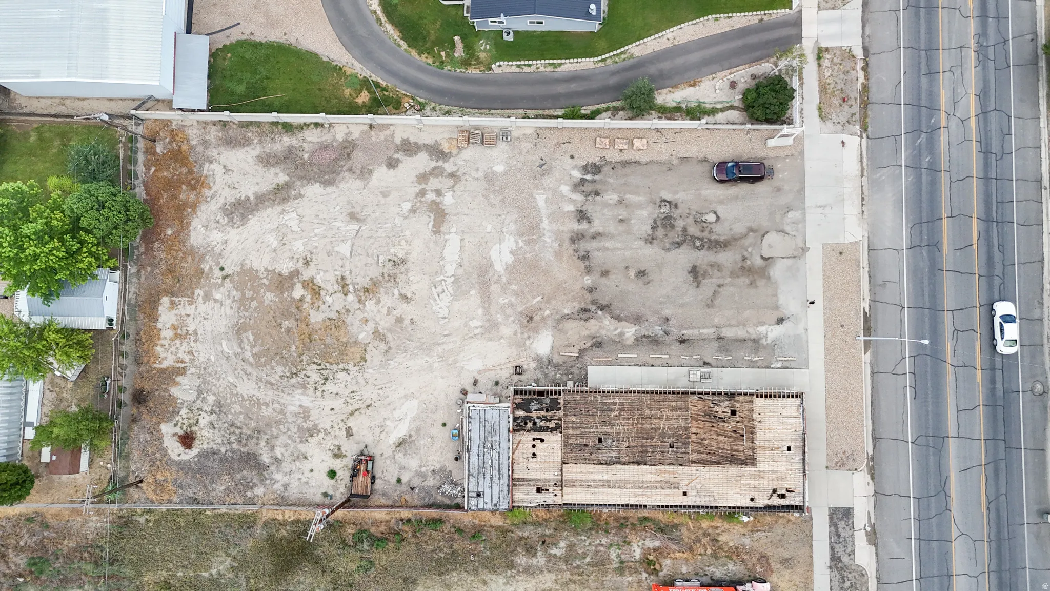 Large lot featuring an existing structure, undeveloped land, and paved road access