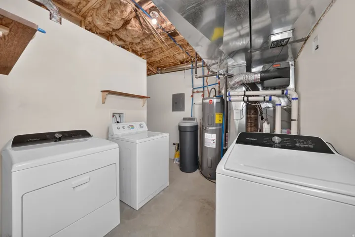 Dedicated utility area featuring a water heater, furnace, and exposed ductwork