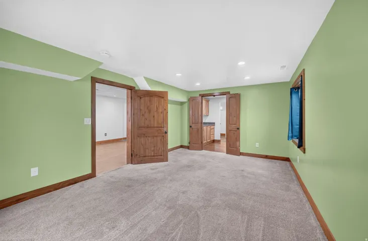 Spacious interior featuring neutral carpeting and a vibrant wall color