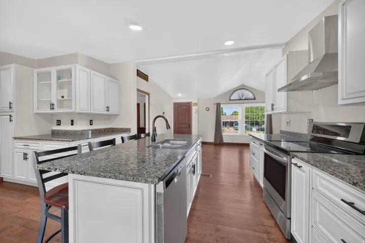 Kitchen featuring white shaker-style cabinetry, granite countertops, and stainless steel appliances