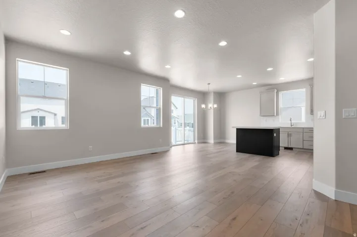 Open-concept living space with light wood-finish flooring, recessed ceiling lighting, and light gray wall paint