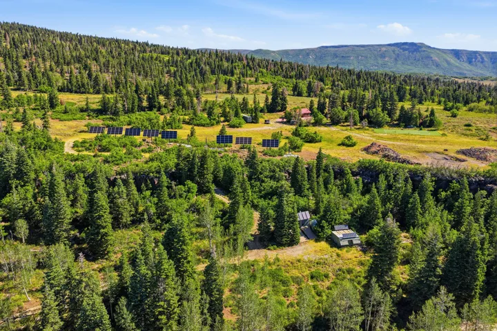 Expansive wooded property featuring multiple solar panel arrays