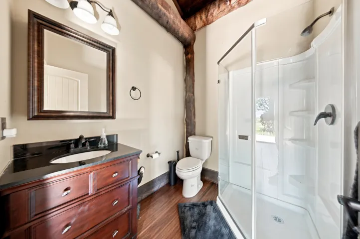 Bathroom featuring a rich wood-finish vanity with a dark countertop, an integrated sink, and dark bronze fixtures