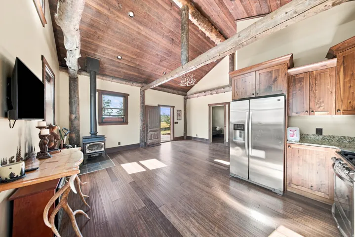 Vaulted wood-plank ceilings with exposed log beams complement the wood-finish flooring