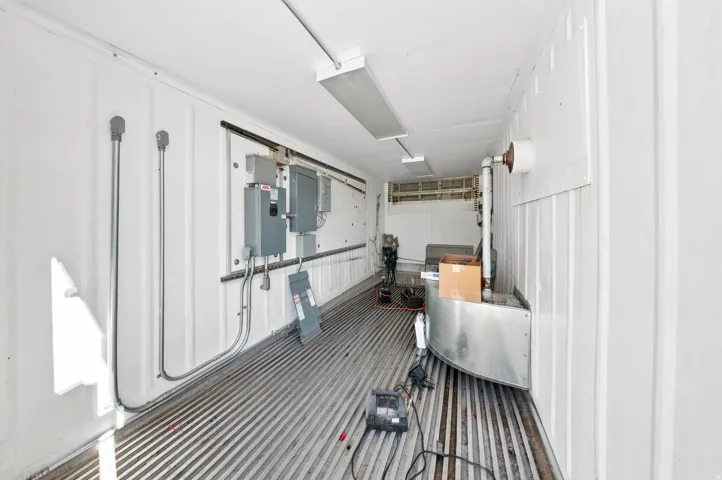 Industrial-style interior with corrugated metal flooring and white paneled walls
