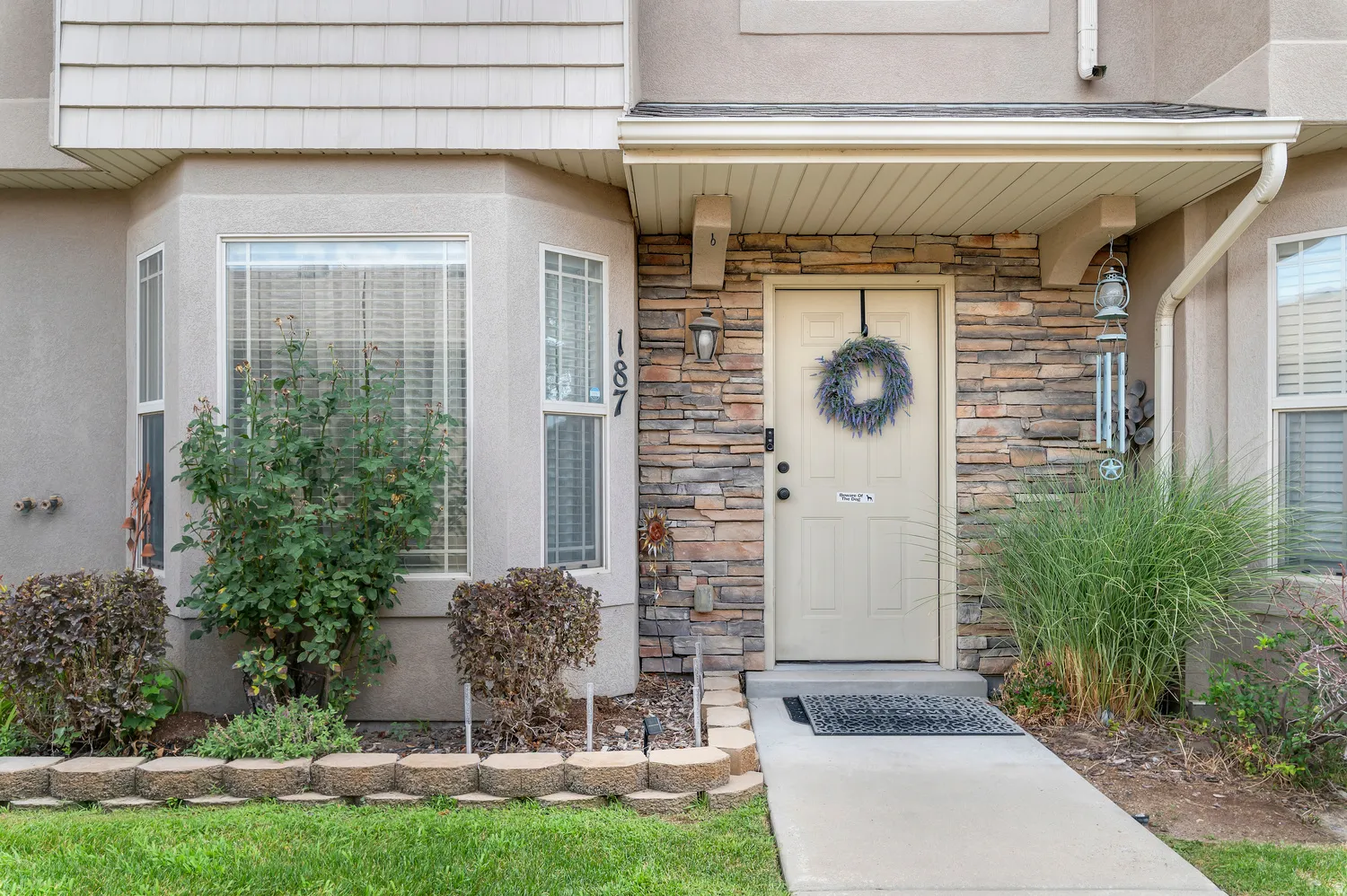 Stone veneer accenting the entryway, complemented by a covered porch with a light-toned door