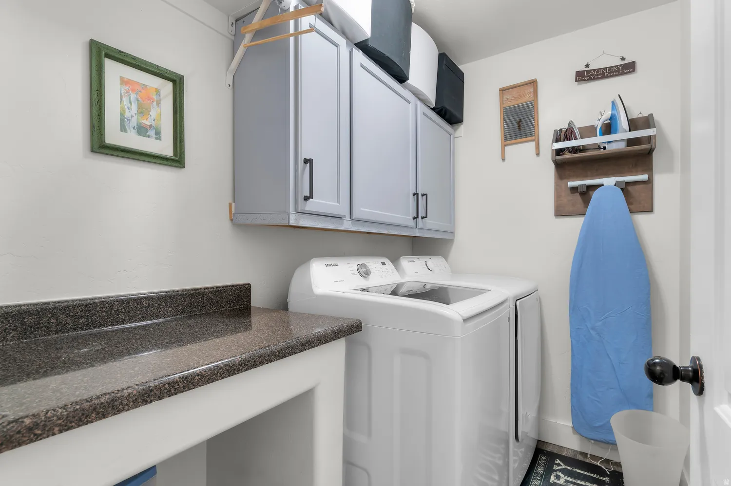 Laundry area featuring a built-in countertop, light gray cabinetry, and white appliances