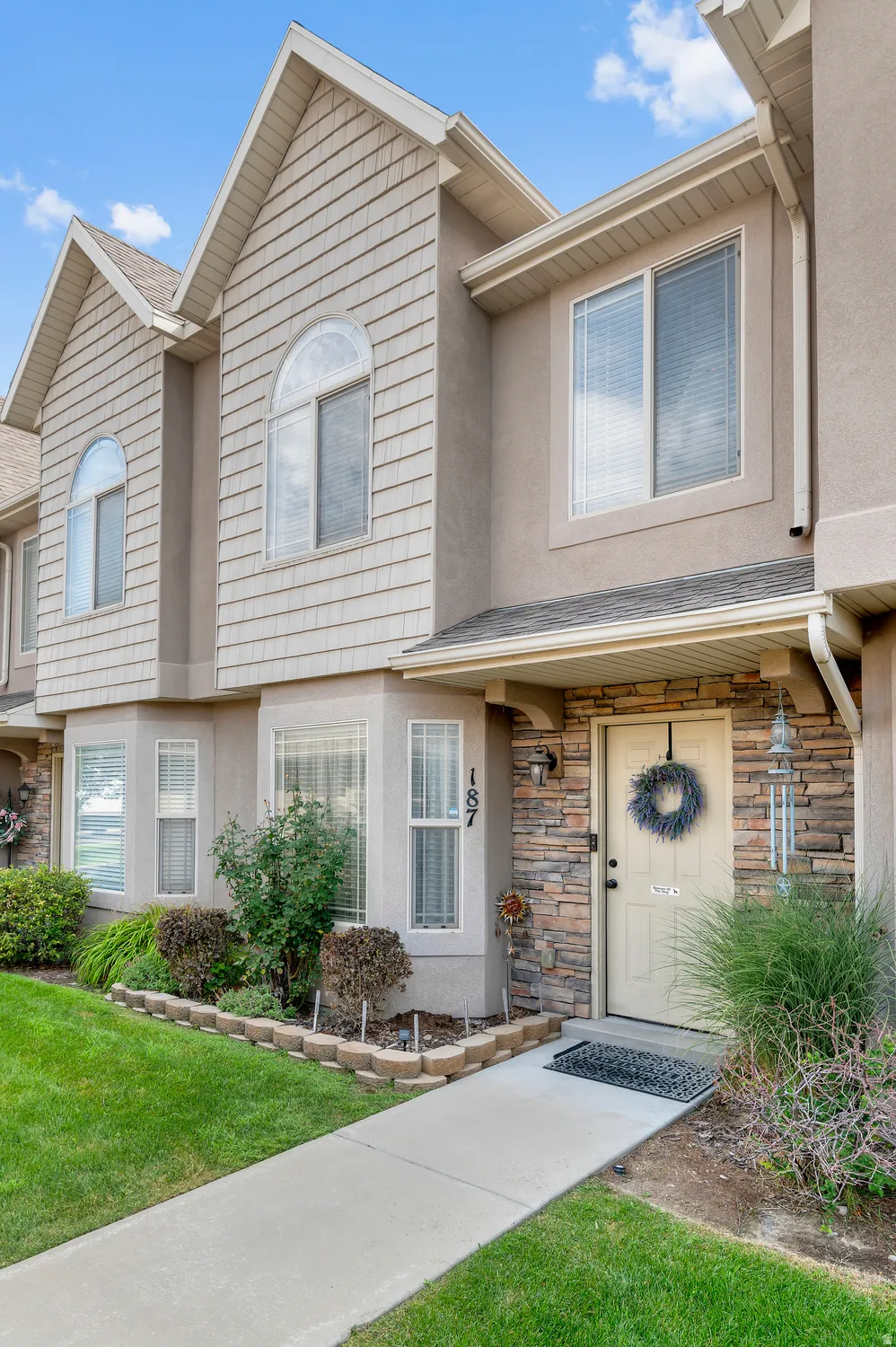 Townhome exterior featuring tan stucco and horizontal siding