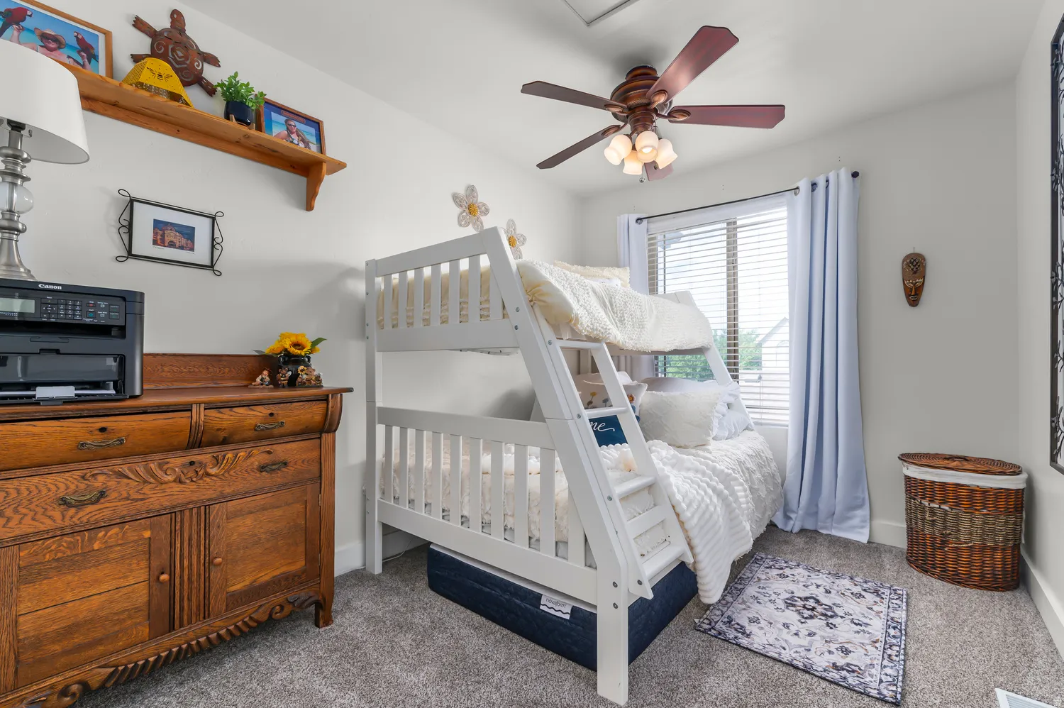 Bedroom featuring a window with blinds, ceiling fan with integrated lighting, and carpet flooring