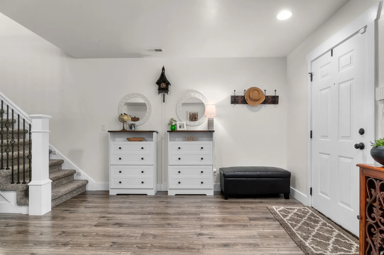 Entryway featuring durable wood-finish flooring and a paneled white door