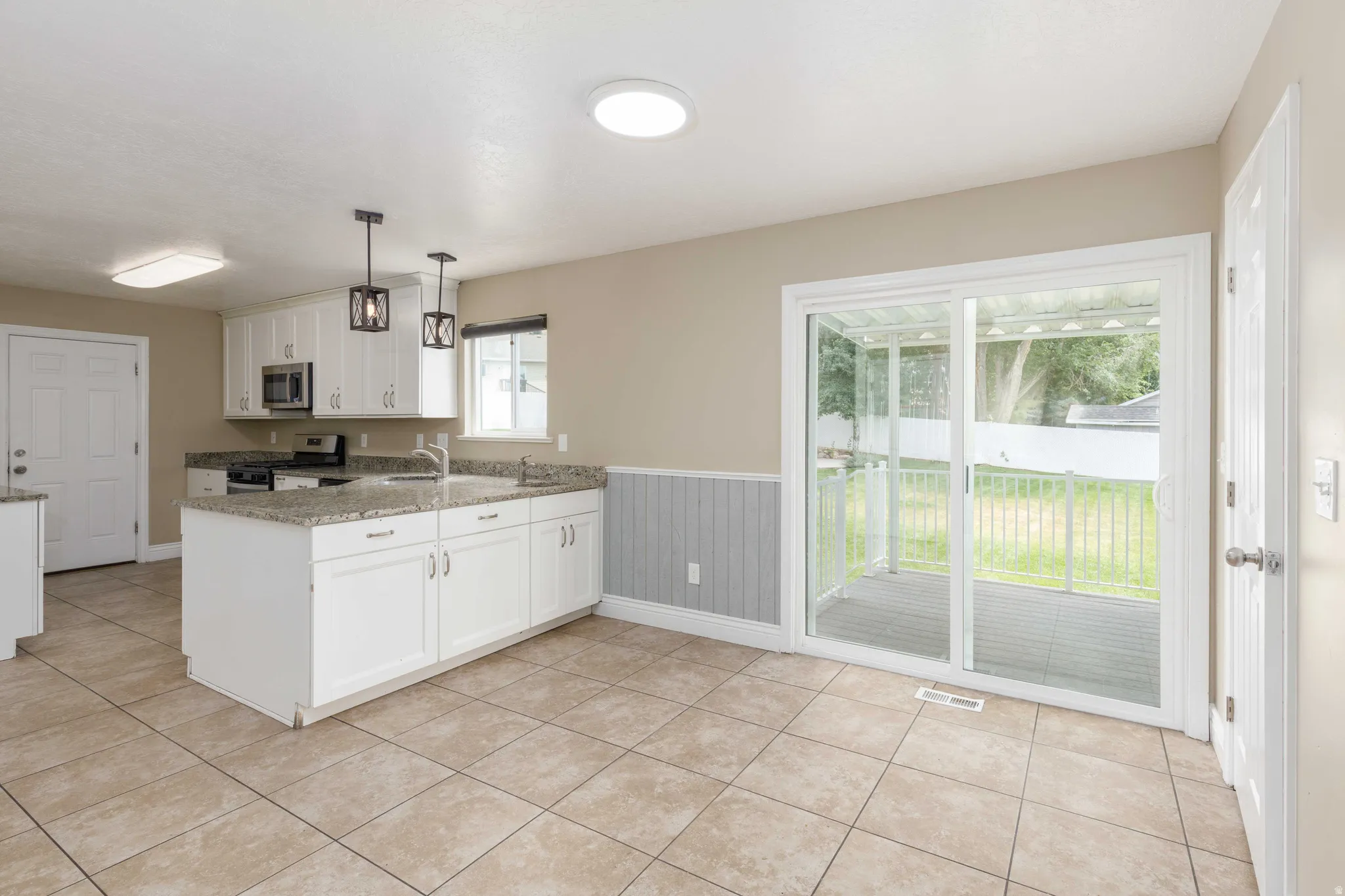 Kitchen featuring a central island, white cabinetry, and granite-look countertops
