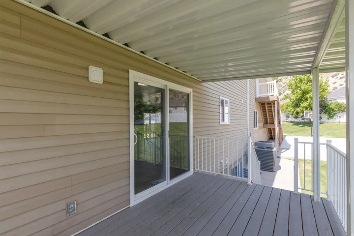 Covered outdoor patio featuring composite decking and white metal railings