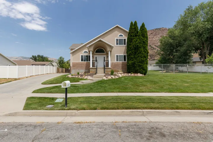 Two-story residence featuring a covered entry porch, arched transom window, and a stone facade accent
