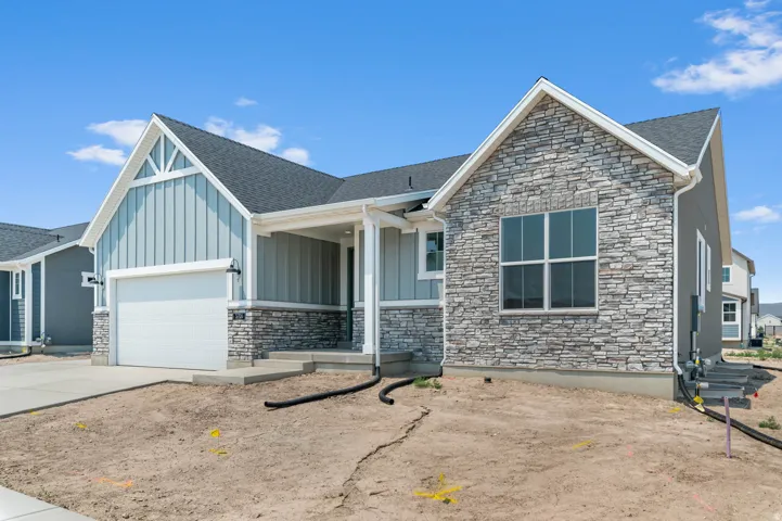 Contemporary single-story residence featuring a combination of stone veneer and vertical siding