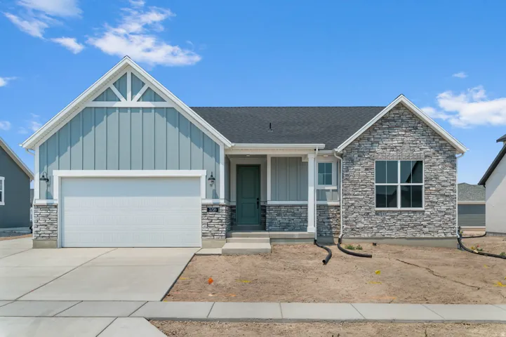 Contemporary single-story residence featuring a two-car garage, light blue vertical siding, and a stacked stone facade