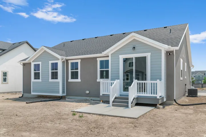 Rear exterior featuring light blue siding, gray stucco, and white trim
