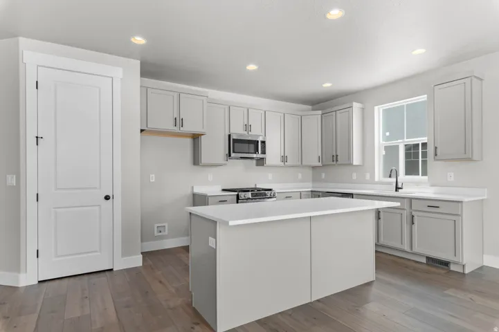 Modern kitchen featuring a central island with a white countertop