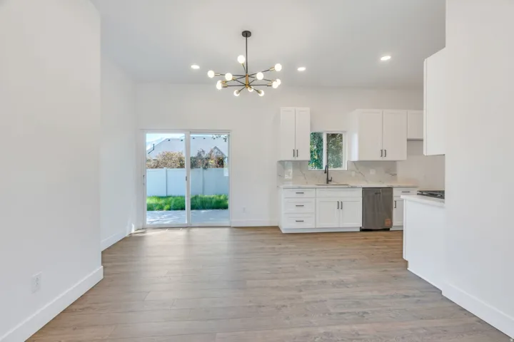 Open-concept living area with wood-finish flooring, recessed lighting, and a modern chandelier